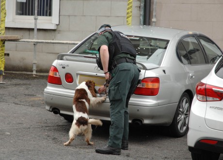 A PSNI dog handler checks the area during the security alert on Monday