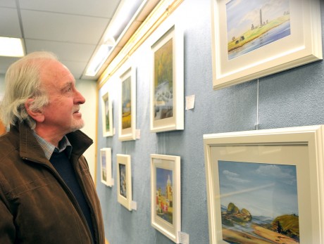 Terry Harpur admiring some of the paintings on display in the Enniskillen Library by the Island Artists gkfh30