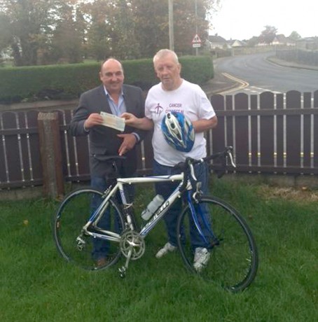 Peter McDonald, right, hands over a cheque to Phil McGrenaghan of Cancer Connect NI.  Peter raised £2000  for Cancer Connect NI by taking part in a cycle from Vietnam to Cambodia. 