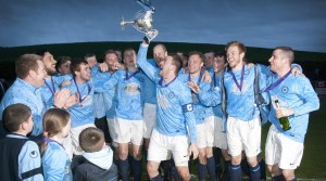 Enniskillen Town United captain Matt McAuley lifts the Mulhern Cup after victory over Beragh in last year's final.