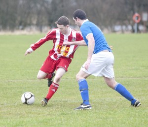 Colin Murray sweeping the ball away from an Orchard City player.