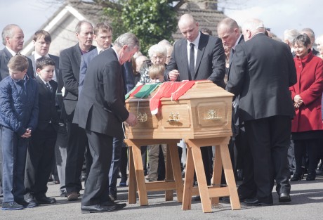 Ollie Swift helps family members attach Pat King's GAA jerseys to his coffin