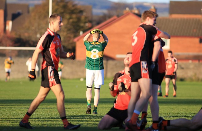Irvinestown players hold their heads as the final whistle blows.