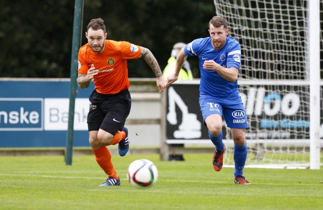 Leon Carters races towards the ball with Carrick player Andrew Doyle in pursuit.