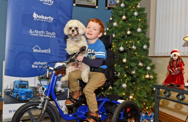 A happy James McCaffrey, gives a lift to Doherty Oils mascot Bubbles, after receiving his new bike for Christmas from Michael Doherty    MC21