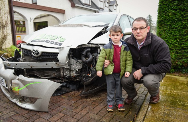 Leo Rice and his son James with their car which was written off after the car clipped a pothole and lost control near Donagh    Picture: Ronan McGrade