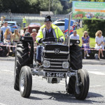 Black Massey - Tom Hughes drives through Donagh Village as a large crowd look on